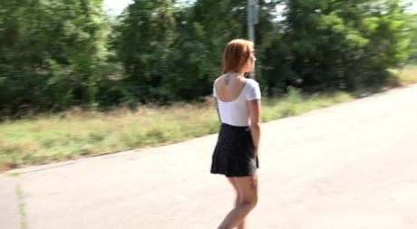 Redhead Foxy Sanie takes a pee on a rural road while a cyclist goes past 32862572